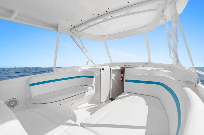  Yacht Photos Pics Interior view of 2018 Intrepid 407 Cuddy boat with white seating and blue accents.