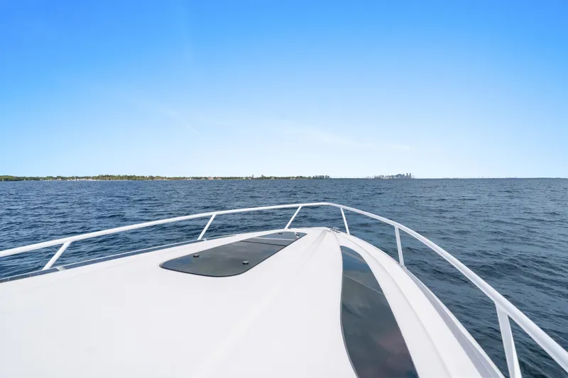  Yacht Photos Pics Bow view of 2018 Intrepid 407 Cuddy cruising on open water under clear blue sky.