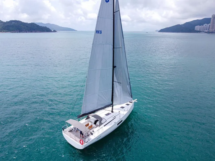  Yacht Photos Pics 2023 Beneteau First 53 sailing on calm waters with scenic coastal backdrop.