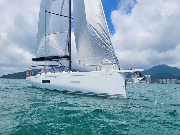  Yacht Photos Pics 2023 Beneteau First 53 sailing on open water under a cloudy sky.