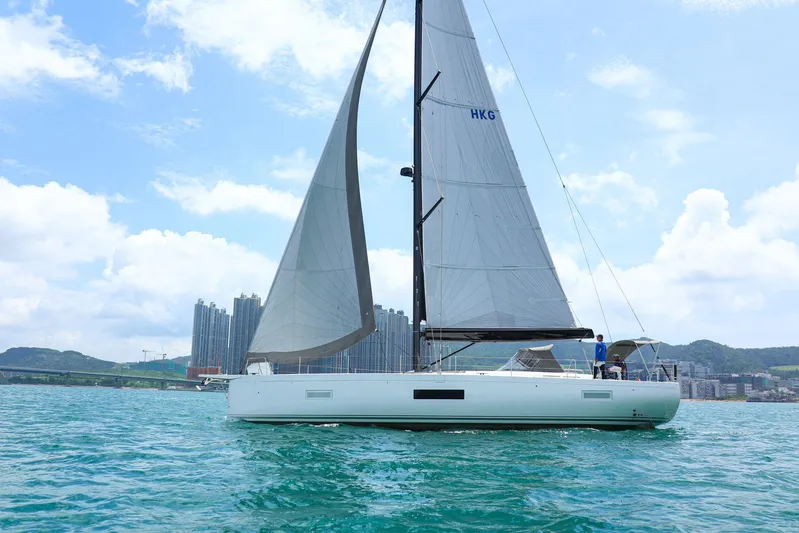  Yacht Photos Pics 2023 Beneteau First 53 sailboat on water, cityscape background, clear sky.