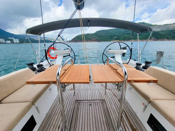  Yacht Photos Pics Cockpit of 2023 Beneteau First 53 yacht with dual steering wheels and wooden deck.
