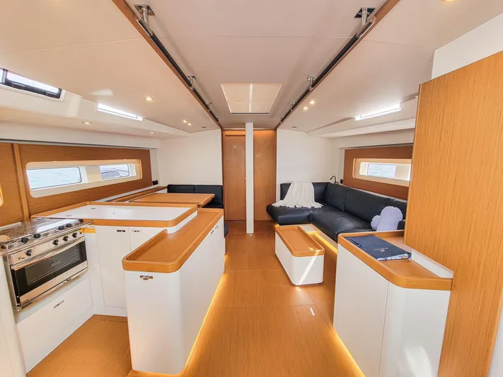  Yacht Photos Pics Luxurious interior of 2023 Beneteau First 53 yacht with modern kitchen and seating area.