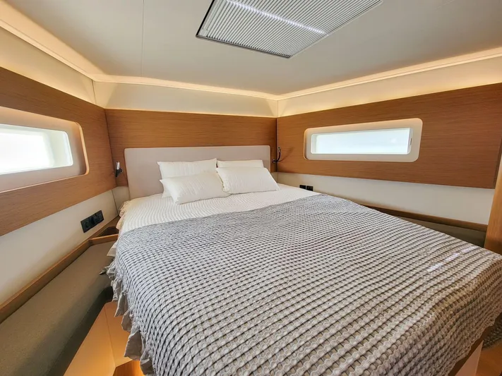  Yacht Photos Pics Luxurious cabin interior of 2023 Beneteau First 53 yacht with cozy bed and modern design.