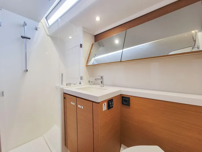  Yacht Photos Pics Modern bathroom interior of 2023 Beneteau First 53 yacht, featuring sleek design and wood accents.
