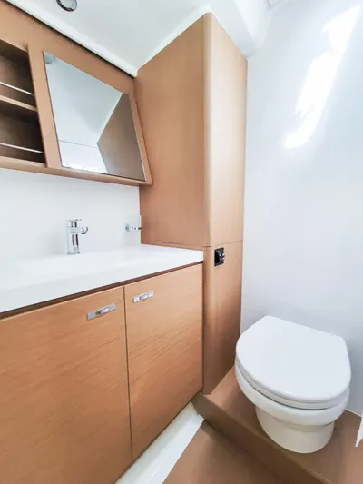  Yacht Photos Pics Modern bathroom in 2023 Beneteau First 53 yacht with wood cabinetry and sleek fixtures.