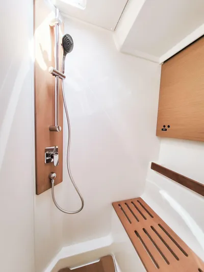  Yacht Photos Pics Shower area in 2023 Beneteau First 53 yacht, featuring modern fixtures and wooden accents.