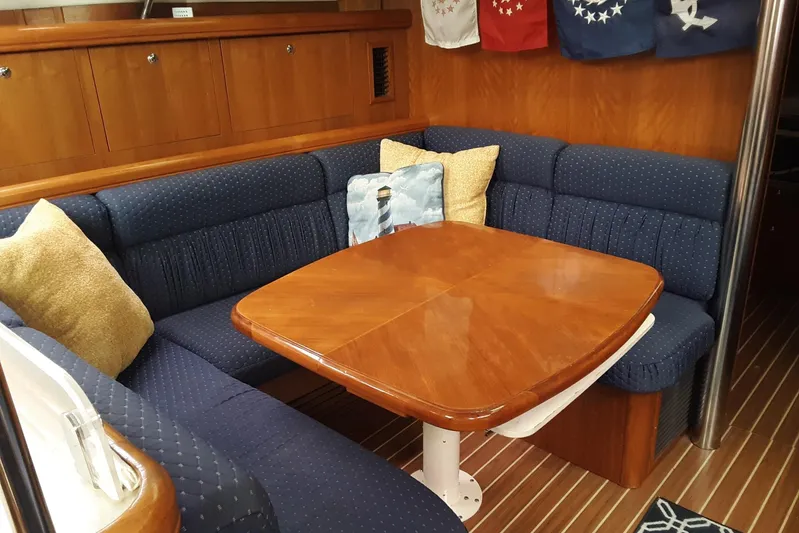 Wind D Yacht Photos Pics Cozy dining area in 2005 Hunter 46LE yacht with wooden table and blue cushioned seating.
