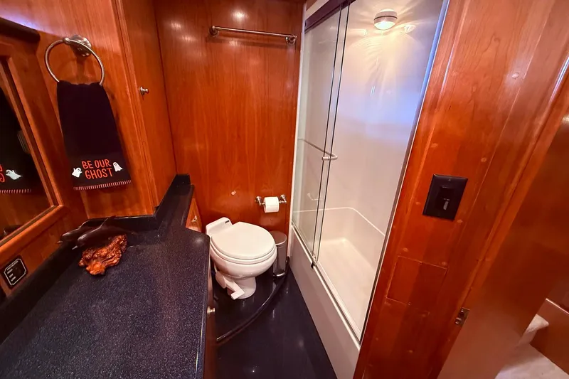  Yacht Photos Pics Luxurious 2007 Navigator 51 yacht bathroom with wood paneling and modern shower.