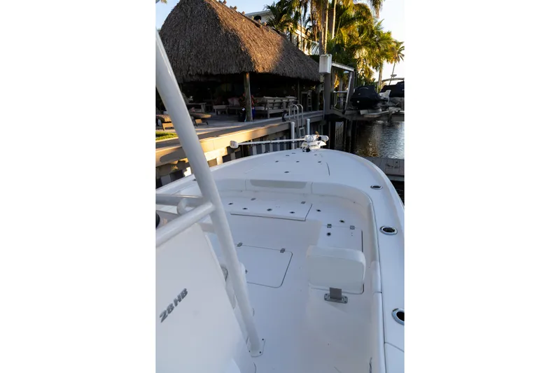  Yacht Photos Pics 2022 Caymas 28 HB Twin boat docked near a thatched-roof structure and palm trees.
