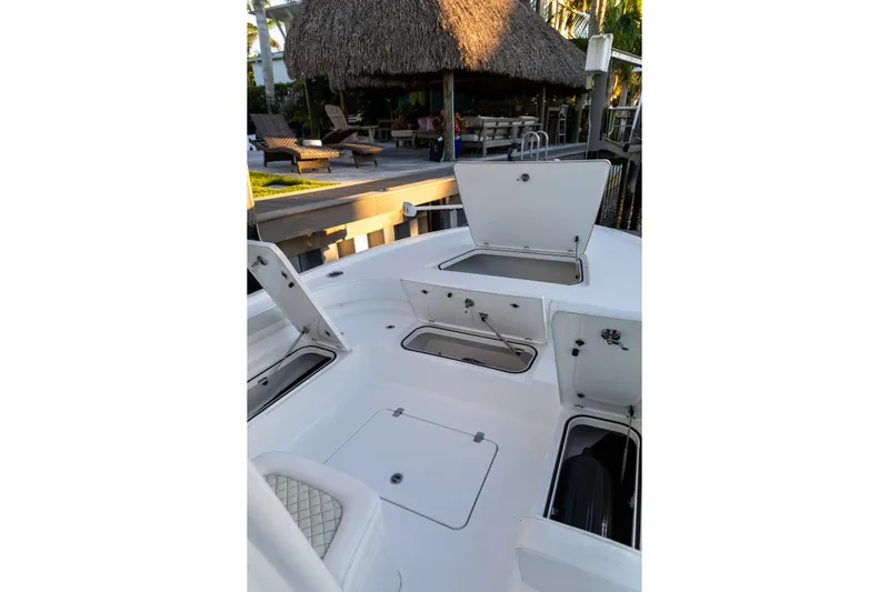  Yacht Photos Pics 2022 Caymas 28 HB Twin boat with open storage compartments, dockside view.