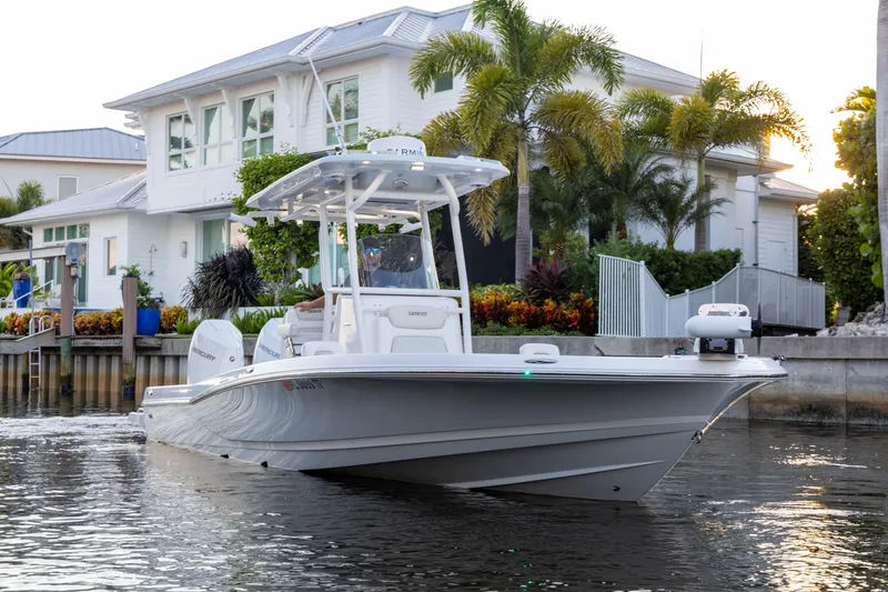  Yacht Photos Pics 2022 Caymas 28 HB Twin boat cruising near waterfront home with palm trees.