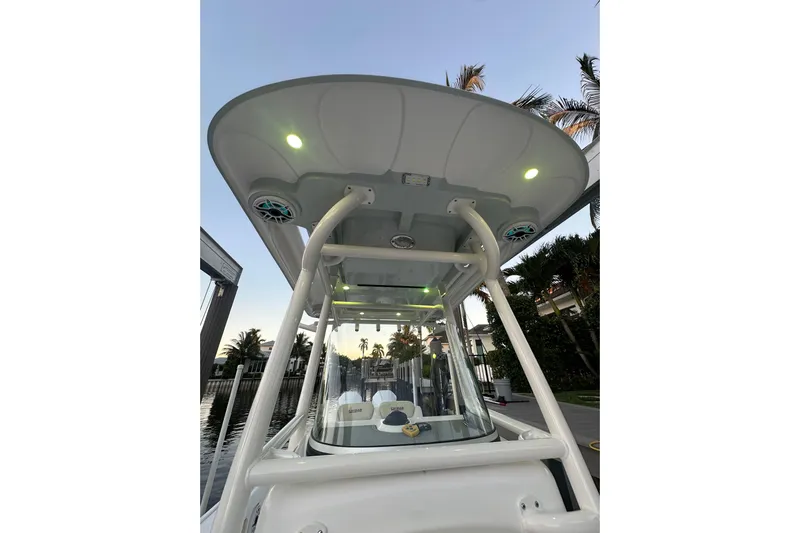  Yacht Photos Pics 2022 Caymas 28 HB Twin boat with illuminated canopy and speakers at sunset.