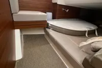 Interior cabin of 2022 Nimbus T11 boat with cushioned seating and wooden accents.