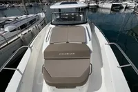 2022 Nimbus T11 boat with cushioned deck, docked in a marina.