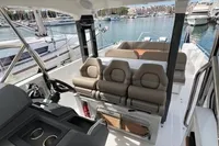 2022 Nimbus T11 boat interior with plush seating and modern helm, docked at a marina.