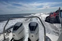 Nimbus T11 boat with dual Mercury engines cruising on open water, displaying a flag.