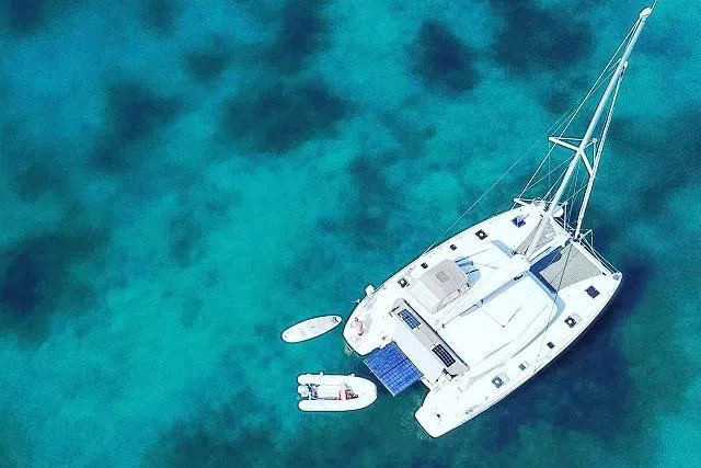 Seafox 1 Yacht Photos Pics Aerial view of 2015 Lagoon 400 S2 catamaran on clear turquoise water.