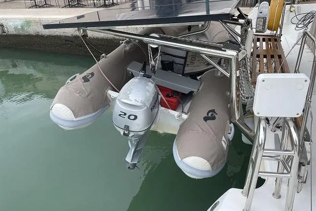Seafox 1 Yacht Photos Pics Catamaran Lagoon 400 S2 (2015) with dinghy and outboard motor, docked in calm waters.
