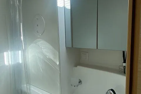 Seafox 1 Yacht Photos Pics Bathroom interior of 2015 Lagoon 400 S2 catamaran, featuring modern fixtures and mirrored cabinets.