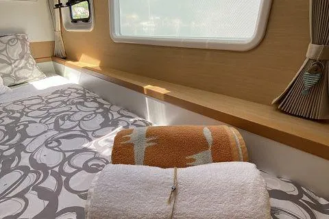 Seafox 1 Yacht Photos Pics Interior cabin of 2015 Lagoon 400 S2 catamaran with cozy bedding and towels.