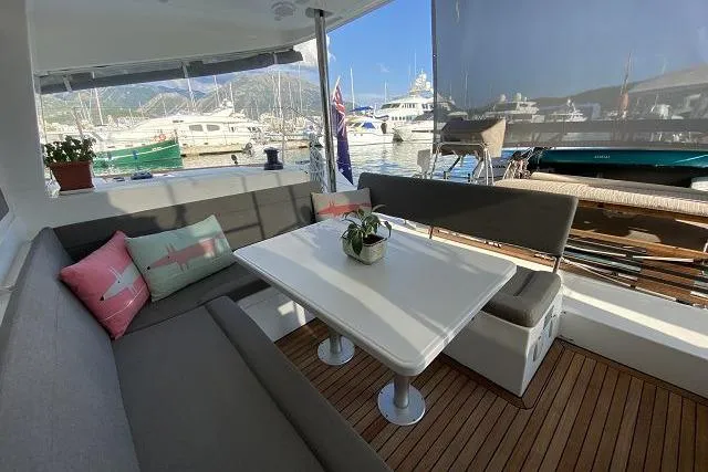 Seafox 1 Yacht Photos Pics Outdoor seating area on 2015 Lagoon 400 S2 yacht, featuring cushions and a table.