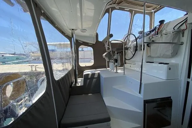 Seafox 1 Yacht Photos Pics Interior view of 2015 Lagoon 400 S2 catamaran cockpit with seating and steering wheel.