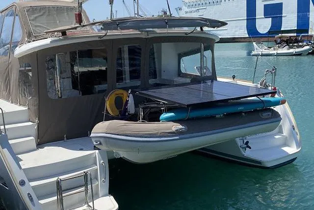 Seafox 1 Yacht Photos Pics 2015 Lagoon 400 S2 catamaran with dinghy and solar panel, docked in a marina.