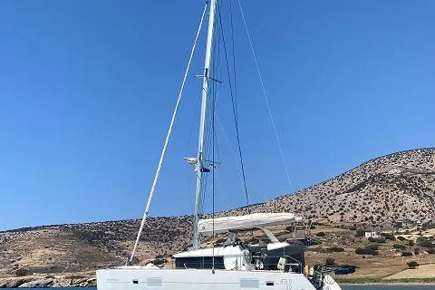 Seafox 1 Yacht Photos Pics 2015 Lagoon 400 S2 catamaran sailing near a rocky coastline under clear blue skies.