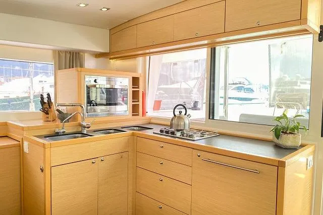 Seafox 1 Yacht Photos Pics Modern kitchen interior of 2015 Lagoon 400 S2 catamaran with light wood cabinetry.