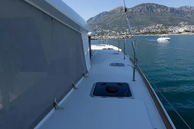 Seafox 1 Yacht Photos Pics 2015 Lagoon 400 S2 catamaran on calm water with mountainous backdrop.