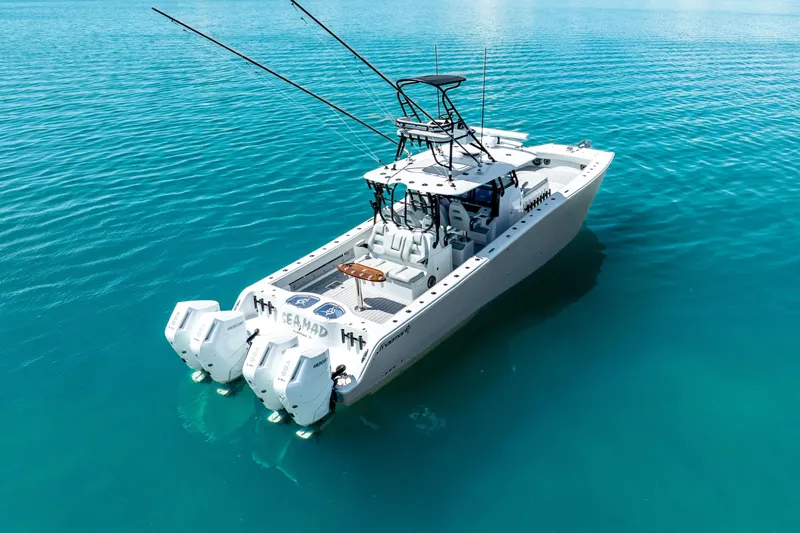  Yacht Photos Pics 2024 Freeman 42 boat on clear blue water, featuring dual outboard engines.