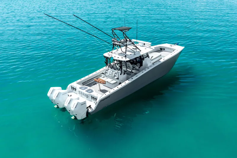  Yacht Photos Pics 2024 Freeman 42 boat on clear turquoise water, featuring dual outboard engines.