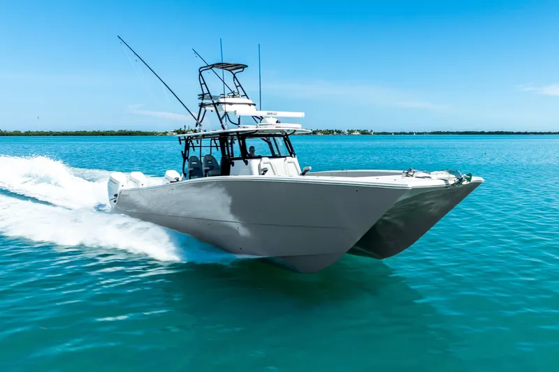  Yacht Photos Pics 2024 Freeman 42 catamaran cruising on clear blue water under a sunny sky.