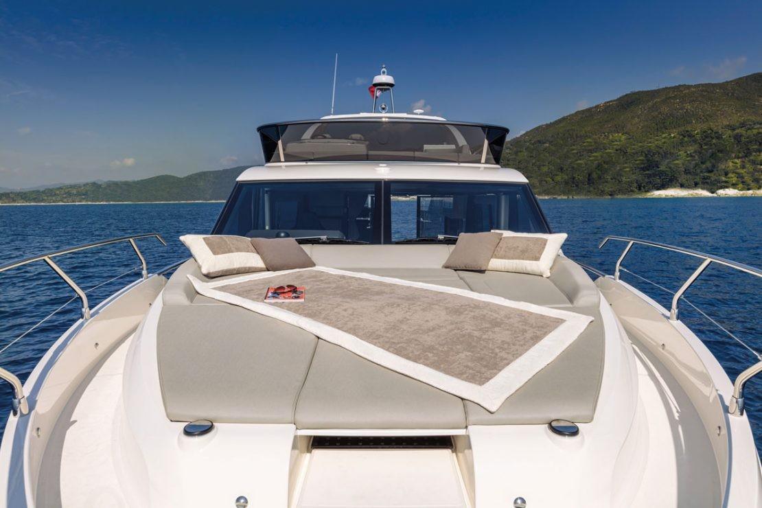 2025 Absolute 47 Fly yacht with sunbathing area, cushions, and scenic ocean view.
