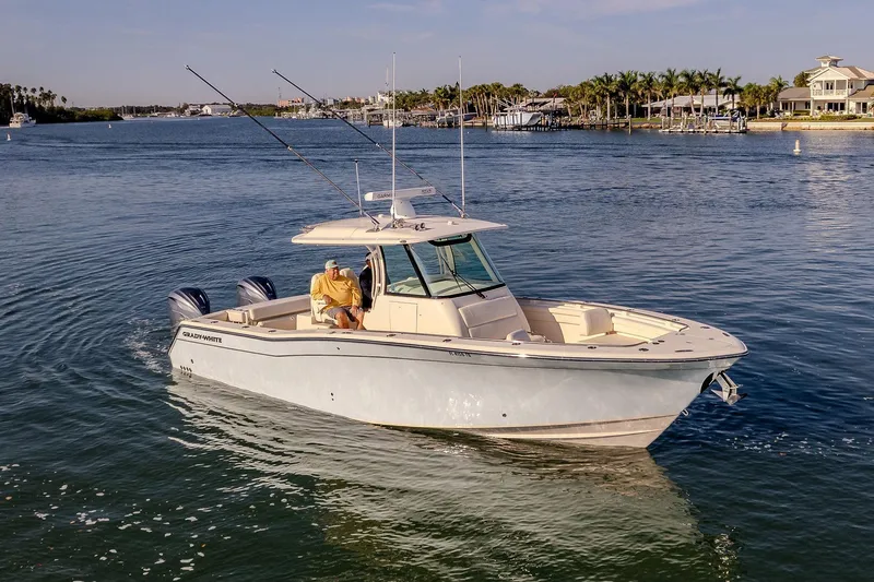  Yacht Photos Pics 2022 Grady-White Canyon 336 boat on calm water near a coastal area.