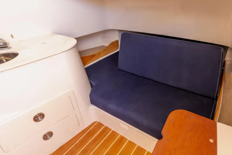  Yacht Photos Pics 2022 Grady-White Canyon 336 cabin interior with blue seating and wooden flooring.