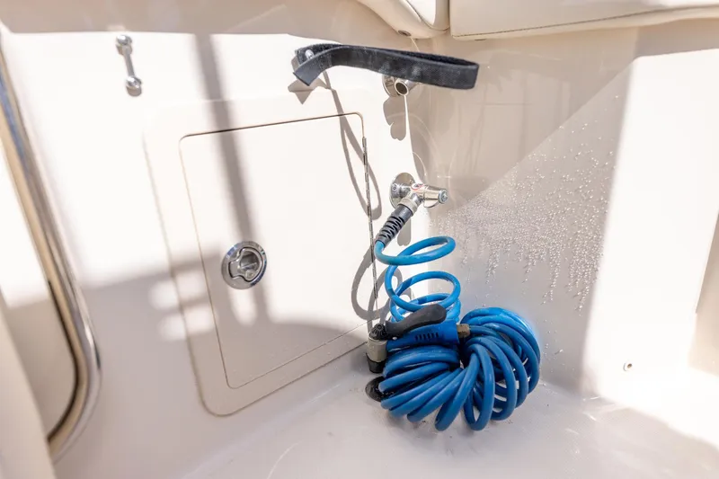  Yacht Photos Pics 2022 Grady-White Canyon 336 boat with coiled blue hose and storage compartment.