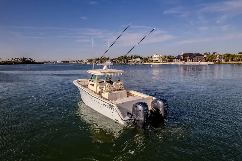  Yacht Photos Pics 2022 Grady-White Canyon 336 boat cruising on a sunny day near waterfront homes.