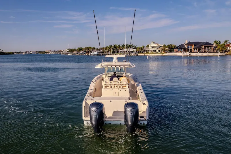  Yacht Photos Pics 2022 Grady-White Canyon 336 boat on calm water near waterfront homes.