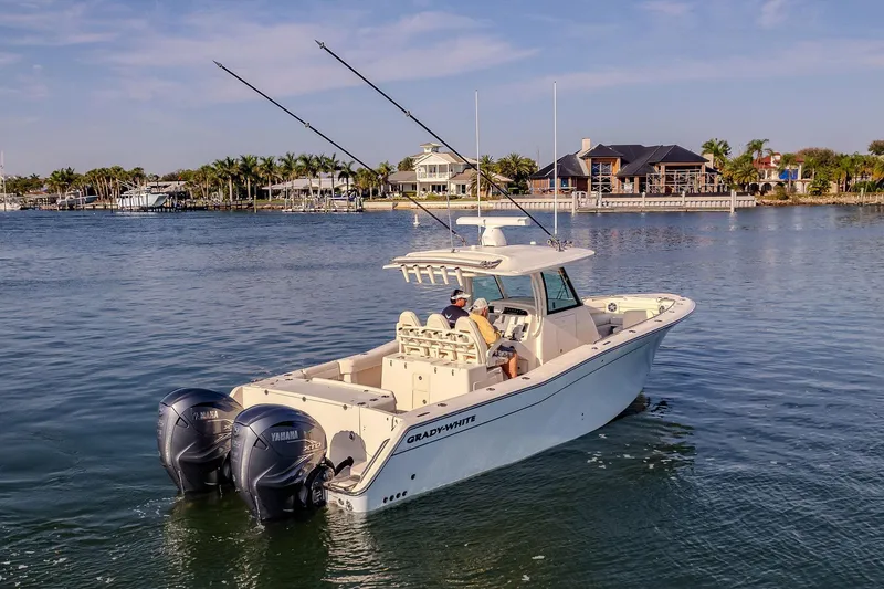  Yacht Photos Pics 2022 Grady-White Canyon 336 boat cruising on a calm waterfront with scenic background.