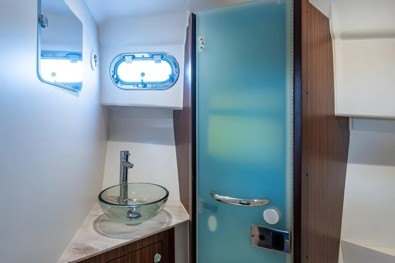  Yacht Photos Pics 2022 Pursuit OS 355 Offshore bathroom with glass sink and frosted door.