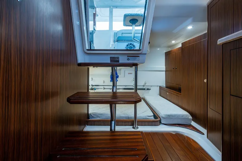  Yacht Photos Pics 2022 Pursuit OS 355 Offshore cabin interior with wooden finish and modern design.