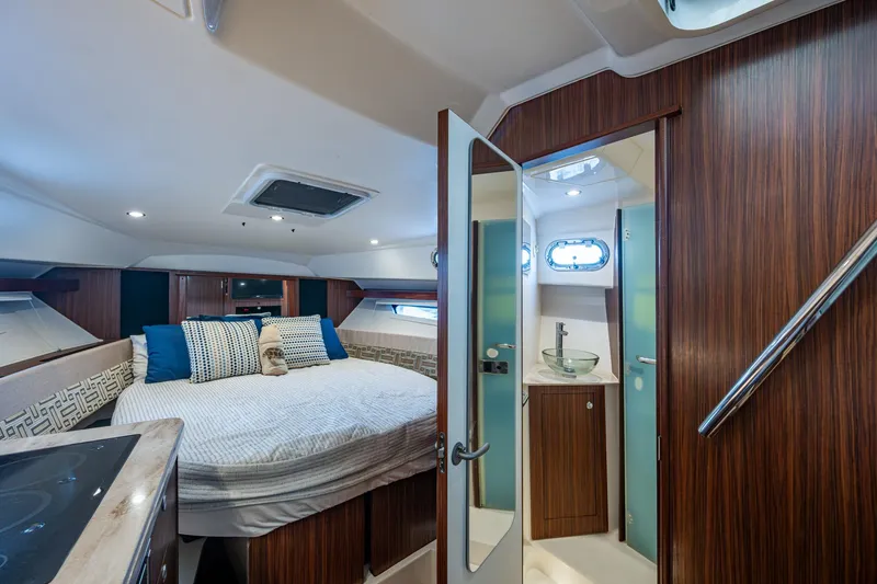  Yacht Photos Pics Luxurious cabin interior of 2022 Pursuit OS 355 Offshore with bed and bathroom.