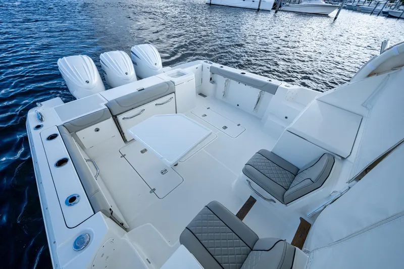  Yacht Photos Pics 2022 Pursuit OS 355 Offshore boat interior with seating and table on water.