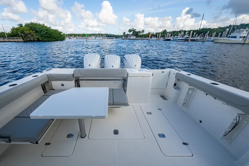  Yacht Photos Pics 2022 Pursuit OS 355 Offshore boat deck with seating and table, overlooking marina.