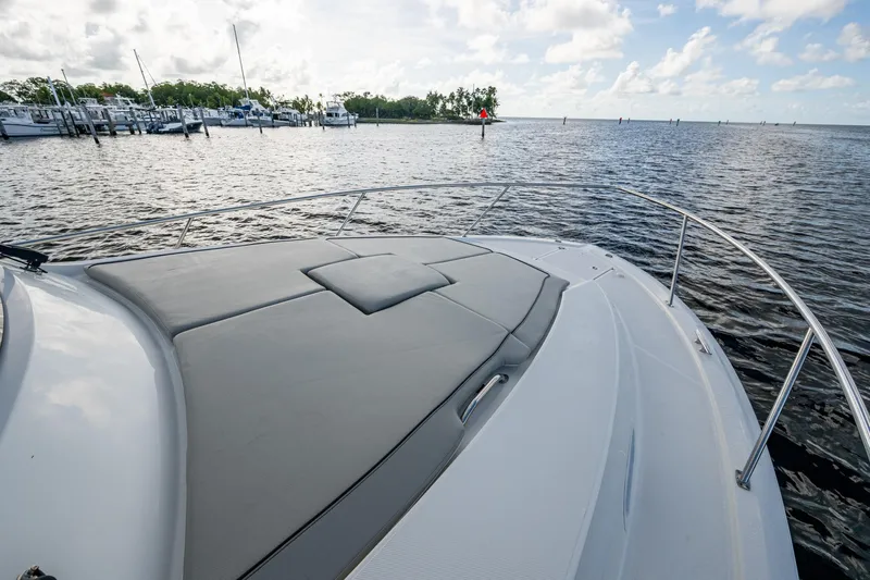  Yacht Photos Pics 2022 Pursuit OS 355 Offshore boat with cushioned deck, docked near marina.