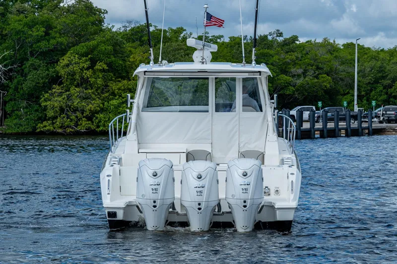  Yacht Photos Pics 2022 Pursuit OS 355 Offshore boat with triple outboard engines on water.