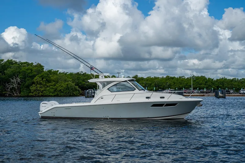  Yacht Photos Pics 2022 Pursuit OS 355 Offshore boat on water with cloudy sky background.