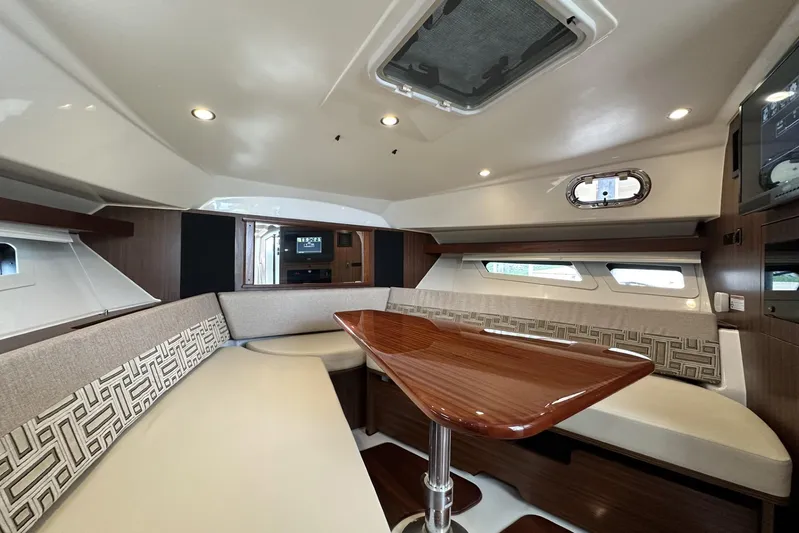  Yacht Photos Pics Luxurious interior of 2022 Pursuit OS 355 Offshore boat with elegant seating and wooden table.
